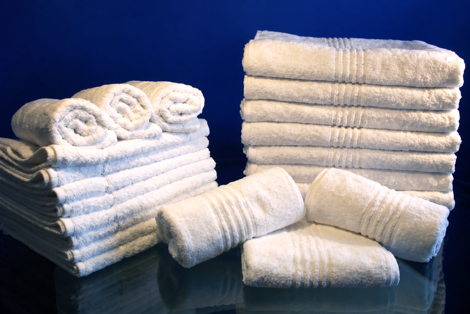 Stacks of large, fluffy white hospitality towels.